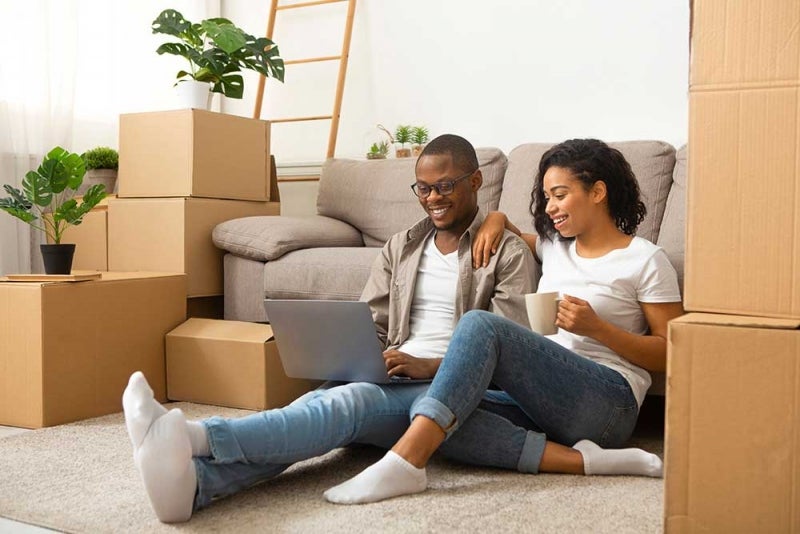 Couple surrounded by boxes on computer