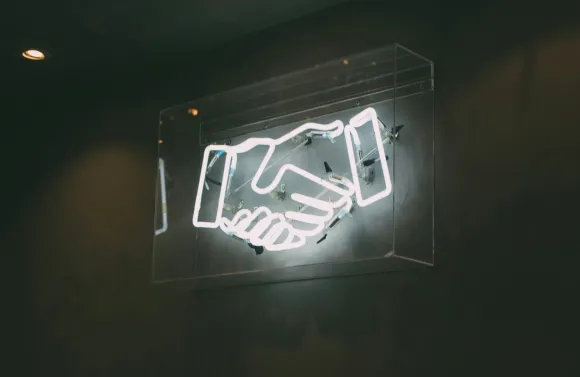neon sign of two hands shaking