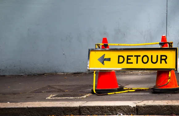 Yellow Direction sign for detour on the footpath