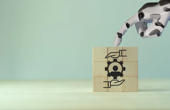Robotic hand placing a block with a gear icon, symbolizing responsible AI in benefits administration.