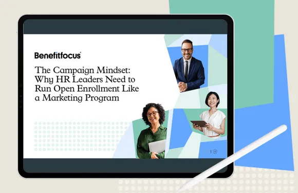 Tablet screen displaying a Benefitfocus ebook cover titled “The Campaign Mindset: Why HR Leaders Need to Run Open Enrollment Like a Marketing Program,” with geometric shapes and three professionals holding a laptop and a tablet.