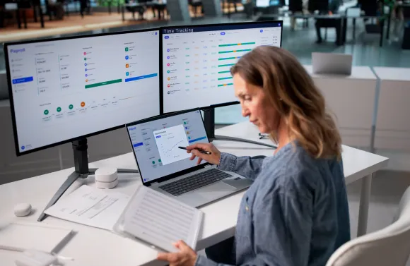 Professional reviewing payroll and employee data for benefits reporting.