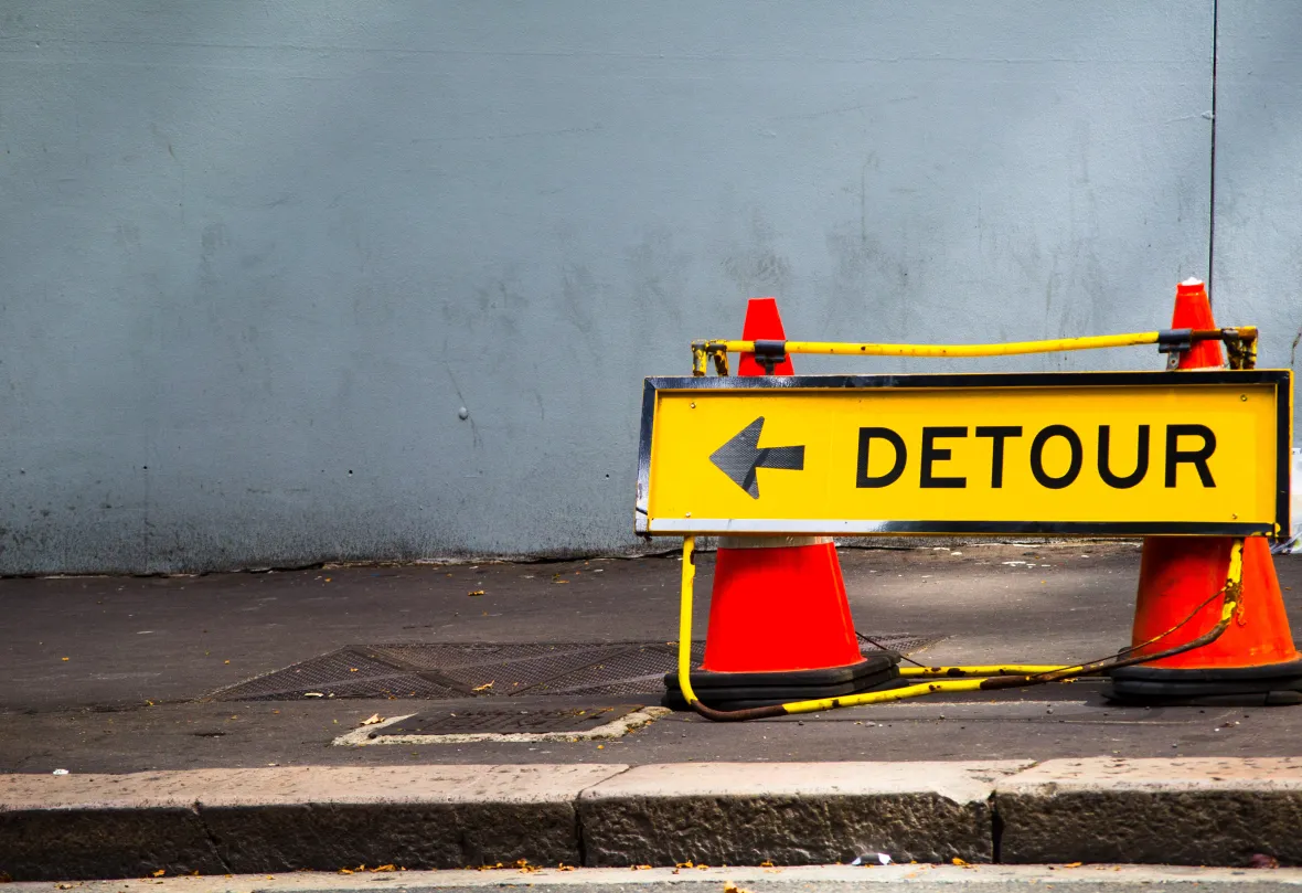 Yellow Direction sign for detour on the footpath
