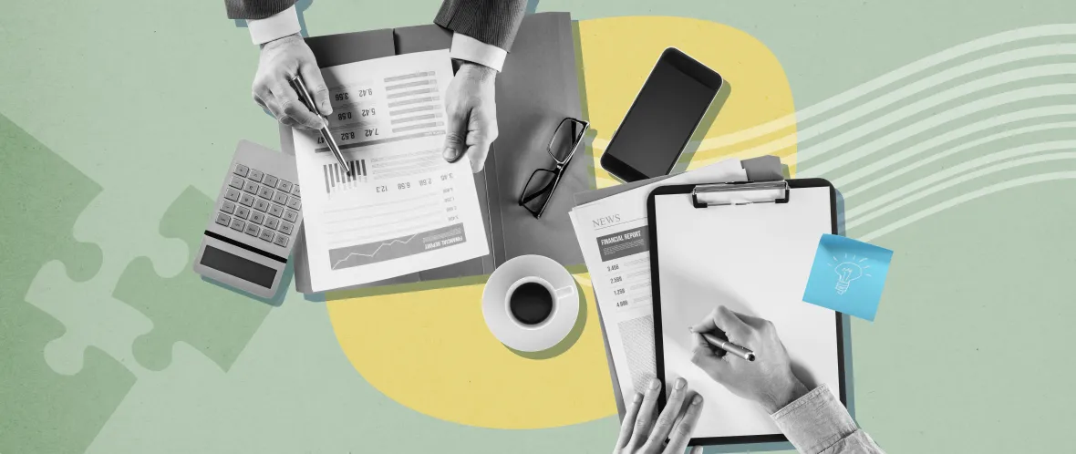 Top view of hands working with documents, clipboard, calculator, phone, and coffee on a desk.