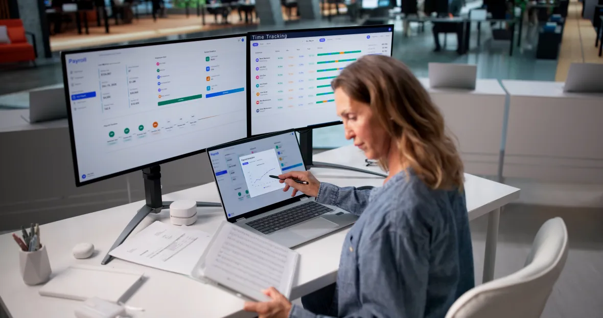 Professional reviewing payroll and employee data for benefits reporting.